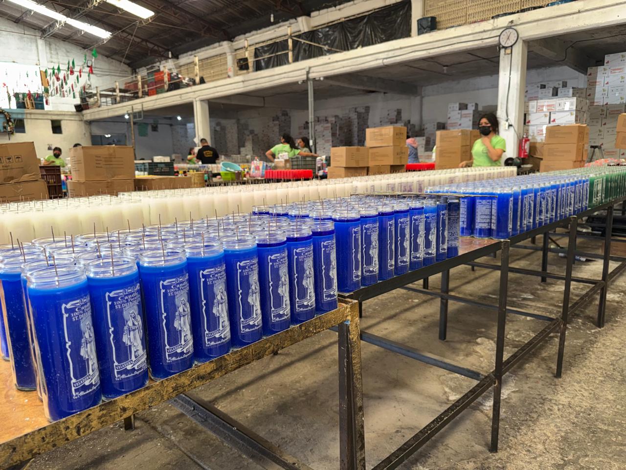 Trabajadoras terminando veladoras azules en la línea de producción